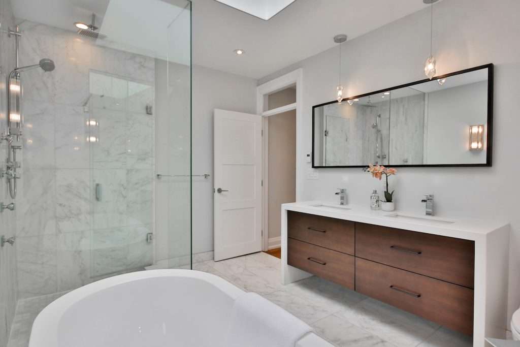 a bathroom with a large white bathtub next to a walk-in shower